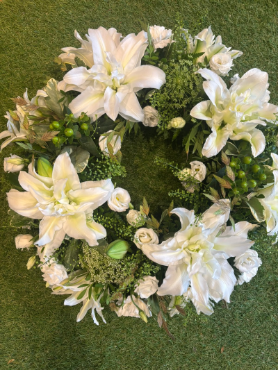 Lily Wreath - A luxurious circular tribute in soft, elegant tones, created to offer comfort, peace and a lasting expression of sympathy.